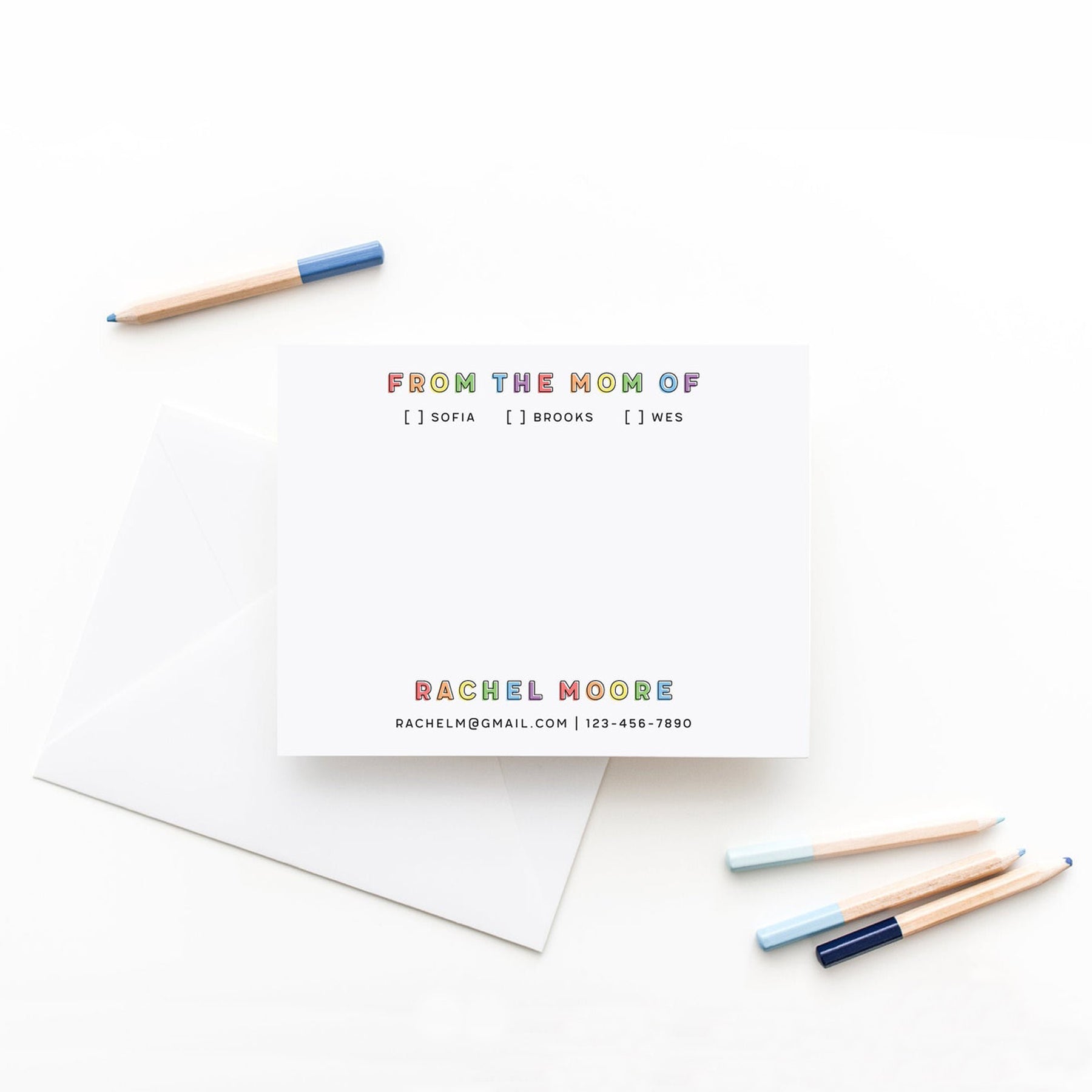 Personalized “Parents Of” notepad with rainbow block lettering, kid checkboxes, and parent contact info styled with white envelopes and pencils.