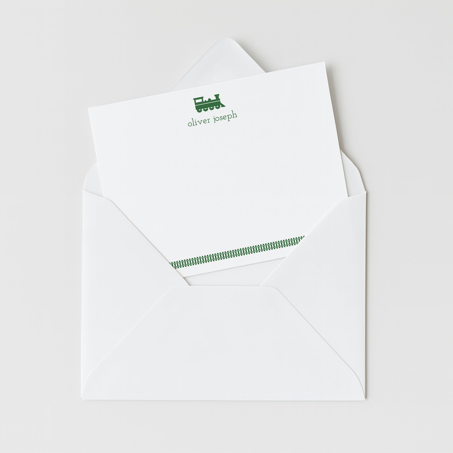 Train personalized note card in green with custom name, shown inside white envelope.