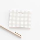 Personalized neutral gingham note card with elegant script name, shown with a cream pen on white background.