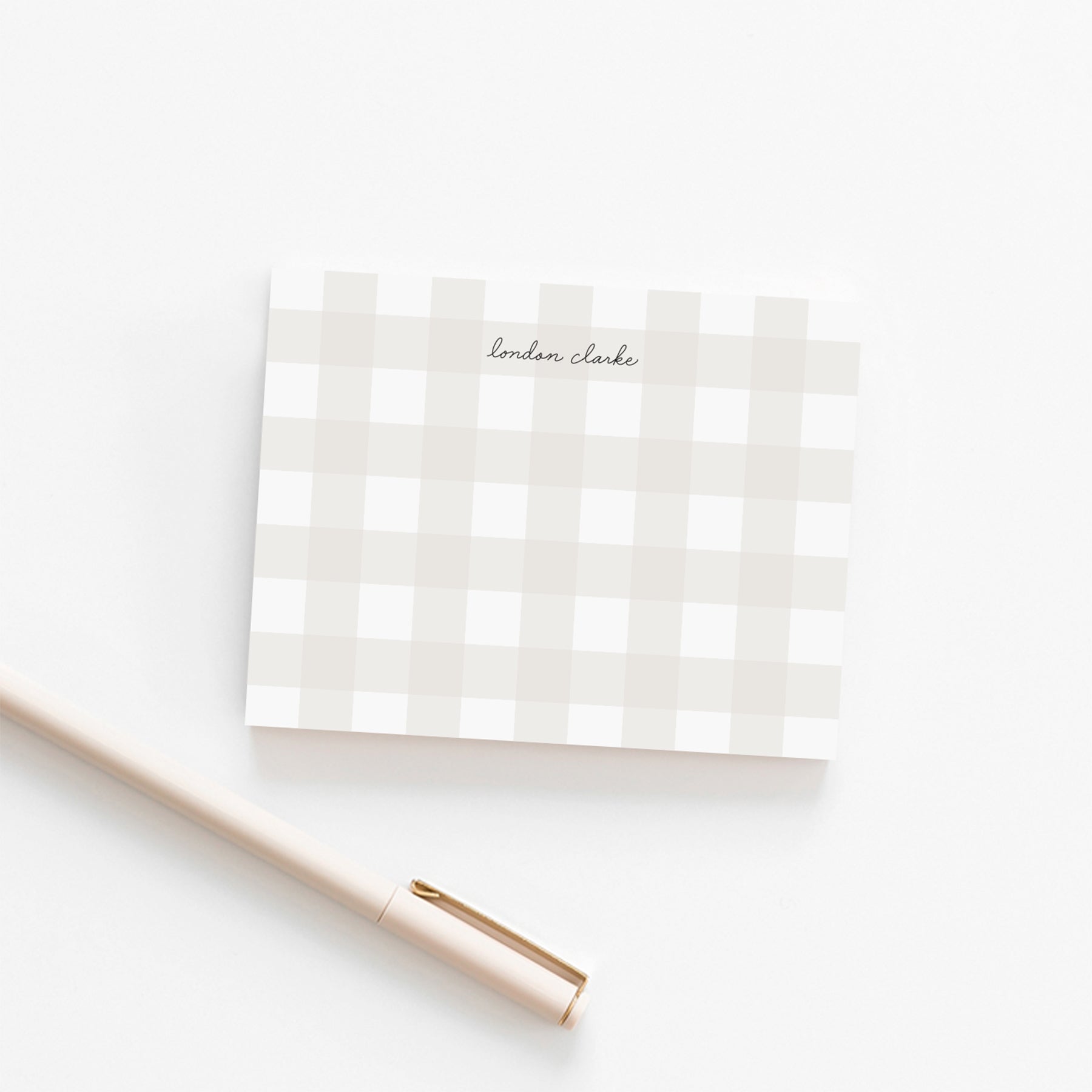 Personalized neutral gingham note card with elegant script name, shown with a cream pen on white background.